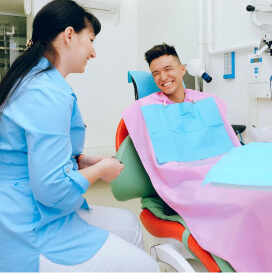 Dentist with his patient talking and smiling